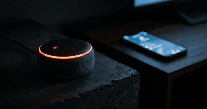 Amazon Echo smart speaker sitting next to a smartphone on a table